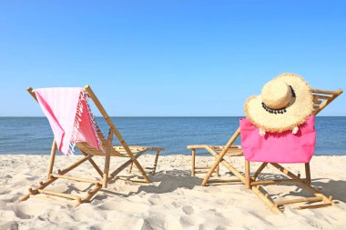 Kumlu sahildeki boş ahşap şezlong ve plaj aksesuarları