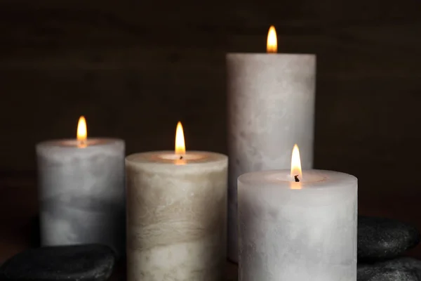 Velas ardientes y piedras de spa sobre fondo oscuro —  Fotos de Stock