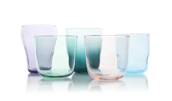 Ensemble de verres vides colorés sur fond blanc — Photo