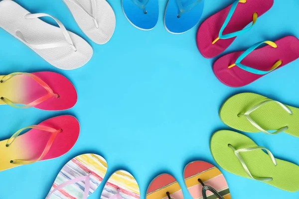 Platte lay compositie met verschillende flip-flops op blauwe achtergrond, ruimte voor tekst. Zomer strand accessoires — Stockfoto