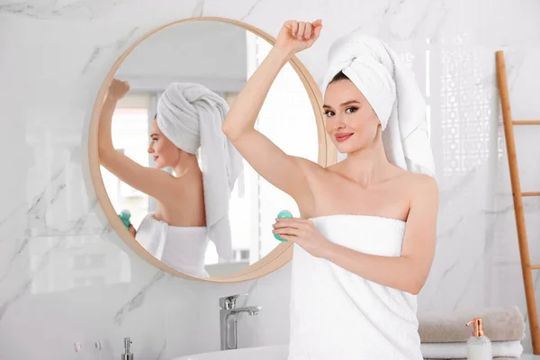 在浴室淋浴后应用除臭剂的美丽的年轻女子 — 图库照片