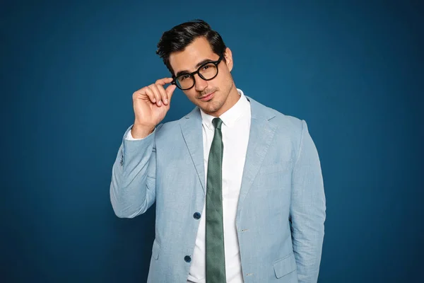 Retrato de joven hombre de negocios guapo con gafas sobre fondo azul —  Fotos de Stock