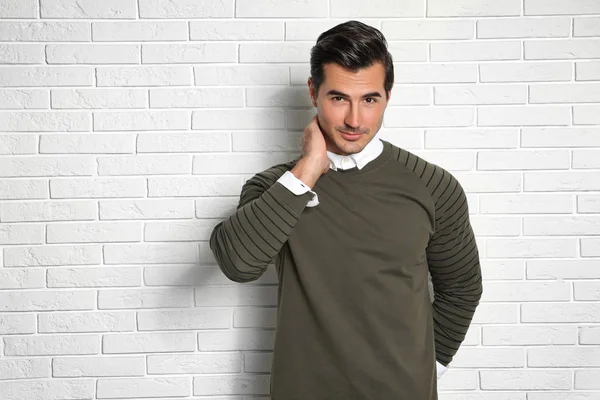 Portrait of handsome young man on white brick wall — Stock Photo, Image