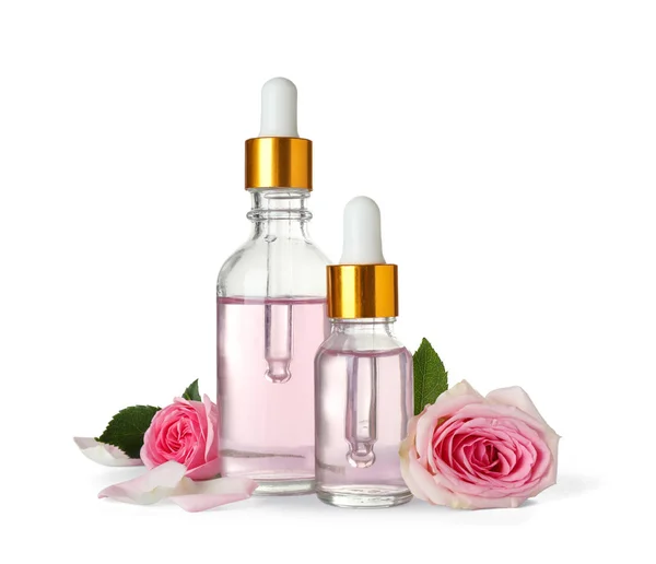 Butelki olejku i róż na białym tle — Zdjęcie stockowe