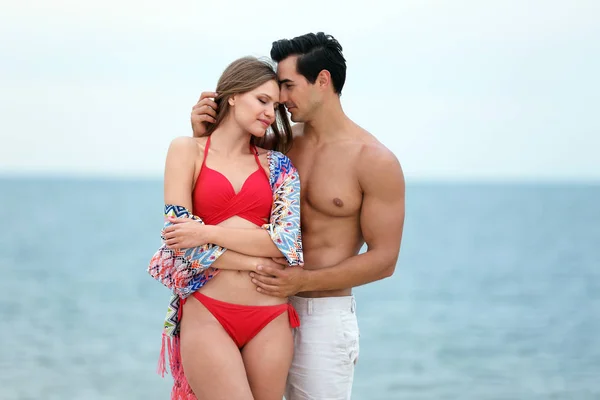 Heureux jeune couple passer du temps ensemble sur la plage de la mer — Photo