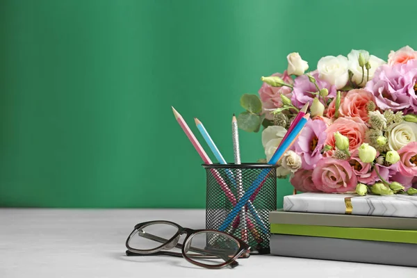 Složení s květinami a sklenicemi pro den učitele na bílém stole — Stock fotografie