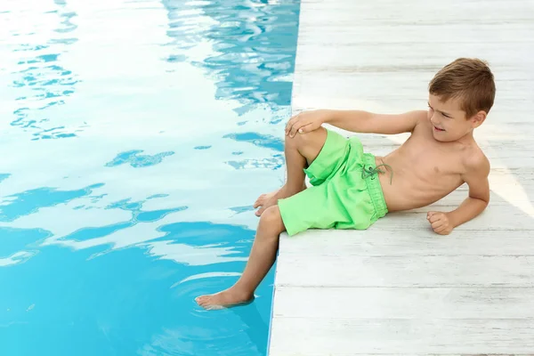 Niño pequeño cerca de la piscina al aire libre. Situación peligrosa — Foto de Stock