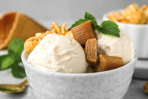 Чаша вкусного мороженого с карамельными леденцами, попкорном и мятой на столе, крупным планом — стоковое фото