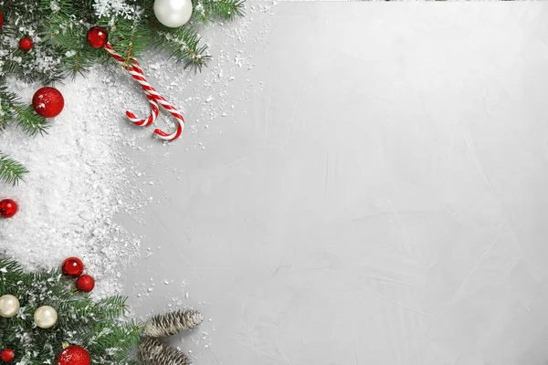 Christmas decoration with white snow on light grey stone background, flat lay. Space for text — Stock Photo, Image