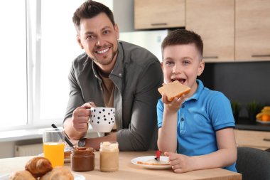Baba ve oğul mutfakta birlikte kahvaltı yapıyor