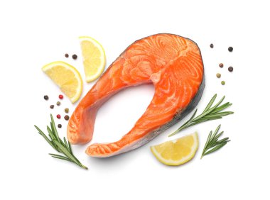 Beyaz arka plan üzerinde biberiye ve limon ile taze çiğ somon biftek, üst görünümü