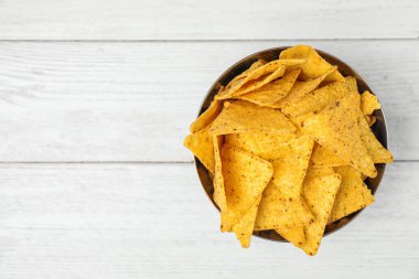 Beyaz ahşap masa üzerinde lezzetli Meksika nachos cips ile Bowl, üst görünümü. Metin için alan