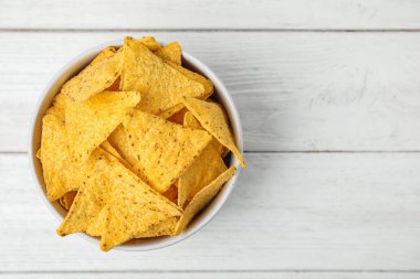 Beyaz ahşap masa üzerinde lezzetli Meksika nachos cips ile Bowl, üst görünümü. Metin için alan