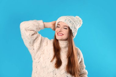 Mavi arka planda Noel süveteri giyen genç kadın