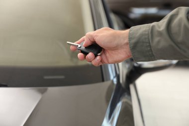 Genç adam araba anahtarı kapalı, closeup ile alarm sistemi kontrol