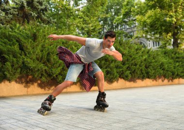 Yakışıklı genç adam paten açık havada paten. Eğlence aktivitesi