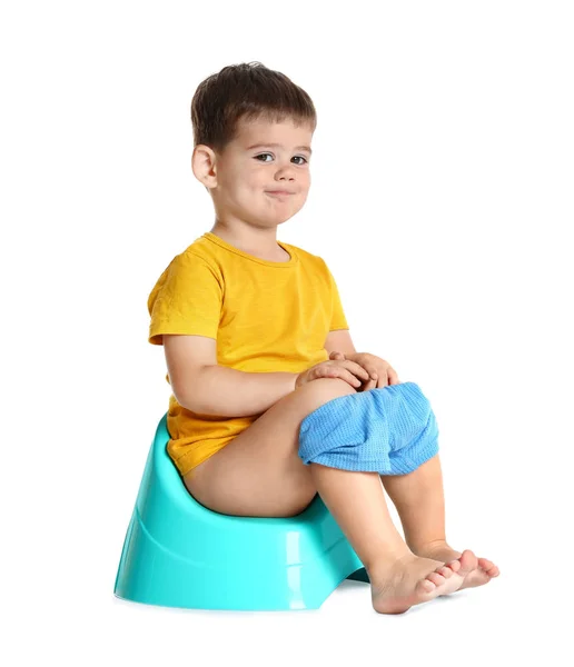 Portrait of little boy sitting on potty against white background — Stock Photo, Image