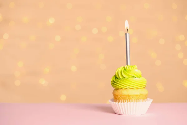 Cupcake di compleanno con candela sul tavolo contro le luci festive, spazio per il testo — Foto Stock