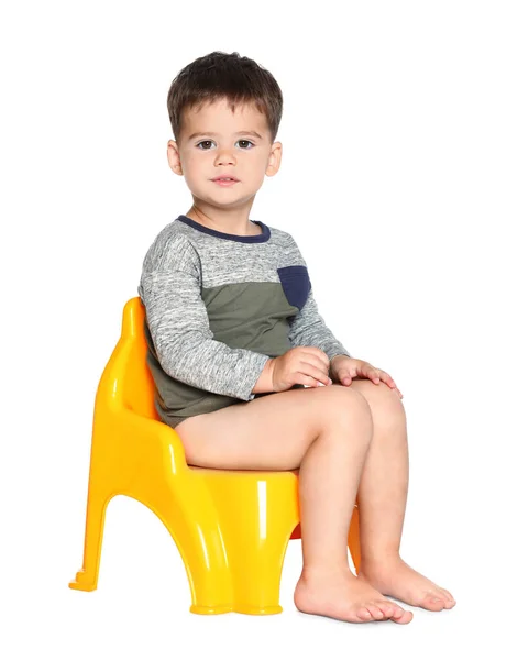 Portrait de petit garçon assis sur un pot sur fond blanc — Photo