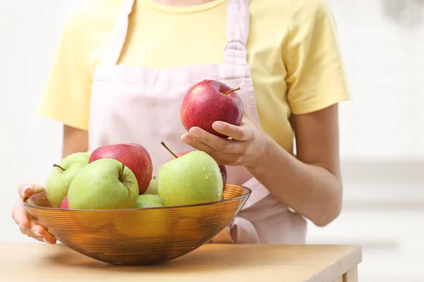 Femme avec bol de pommes fraîches à table dans la cuisine, gros plan — Photo
