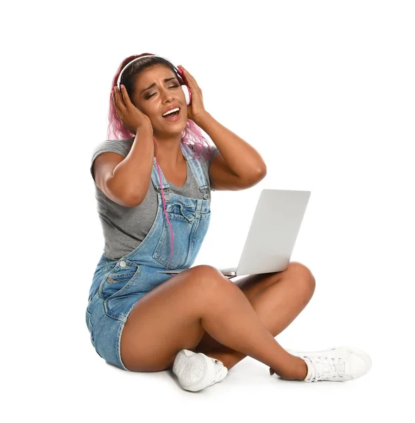 情感的西班牙裔妇女与笔记本电脑在白色背景听音乐 — 图库照片