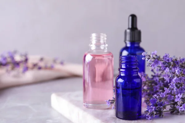 Botellas de aceite esencial de lavanda sobre mesa de mármol. Espacio para texto — Foto de Stock