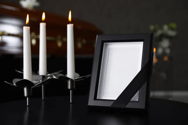 Black photo frame with burning candles on table in funeral home — Stock Photo, Image