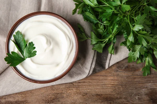 Flat lay composition with sour cream and parsley on wooden table — Stock Photo, Image