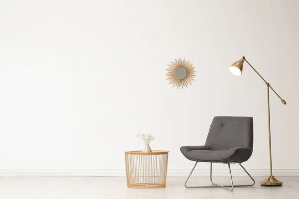 Snygg vardagsrums inredning med skön stol och sidobord nära vita muren. Utrymme för text — Stockfoto