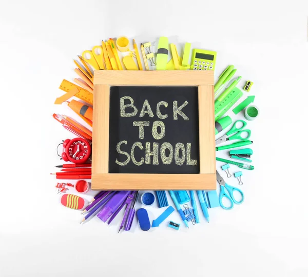 Schoolbord met zin "terug naar school" en verschillende briefpapier op witte achtergrond, bovenaanzicht — Stockfoto