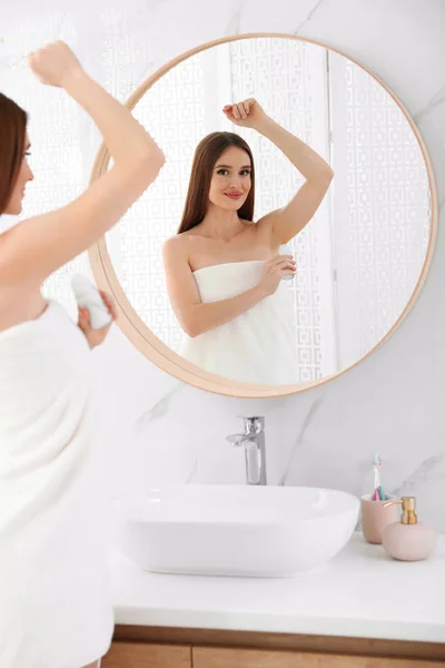 Bella giovane donna che applica il deodorante dopo la doccia in bagno — Foto Stock