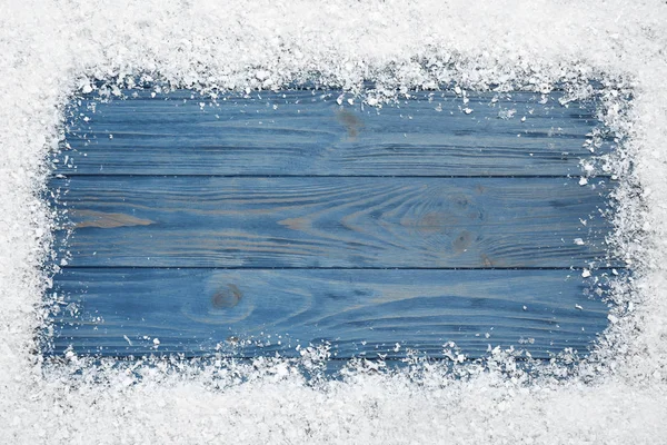 Mavi ahşap arka plan üzerinde beyaz kar çerçevesi, metin için alan ile üst görünüm. Noel sezonu — Stok fotoğraf
