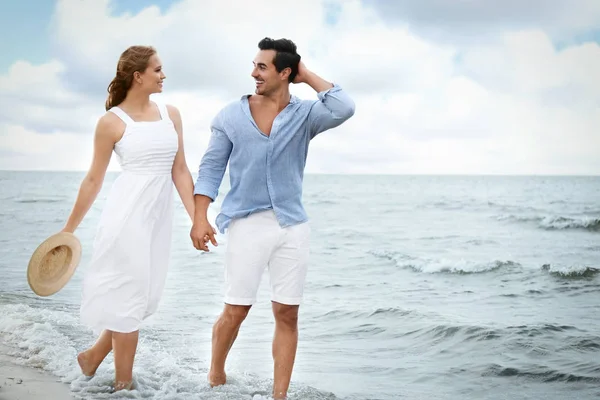 Gelukkige jonge paar wandelen aan zee strand — Stockfoto