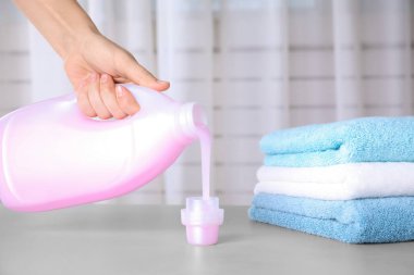 Bulanık arka plana karşı masanın üzerine çamaşır deterjanı döken kadın, yakın çekim