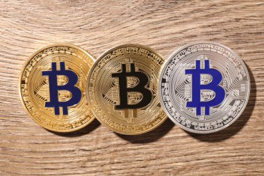 Ahşap arka planda parlak Bitcoins, düz yatıyordu. Dijital para birimi