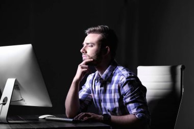 Konsantre genç adam geceleri ofiste yalnız çalışan