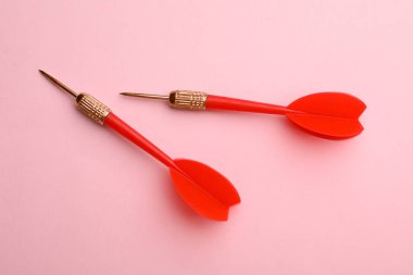 Pembe arka plan üzerinde kırmızı dart okları, düz yatıyordu
