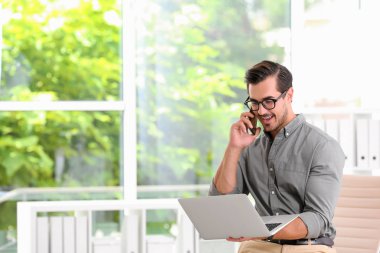 Yakışıklı genç adam kapalı dizüstü bilgisayar ile çalışıyor. Metin için alan