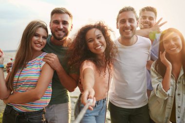 Güneşli bir günde dışarıda selfie çeken mutlu gençler