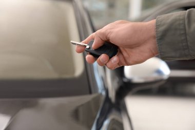 Genç adam araba anahtarı kapalı, closeup ile alarm sistemi kontrol