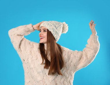 Mavi arka planda Noel süveteri giyen genç kadın