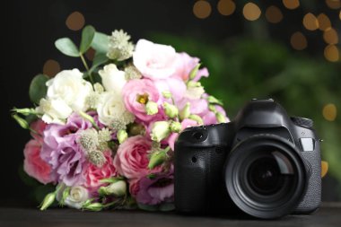 Siyah ahşap masa üzerinde modern kamera ve buket. Uluslararası Fotoğrafçılar Günü