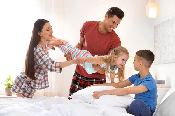 Jovem família feliz com crianças se divertindo no quarto — Fotografia de Stock