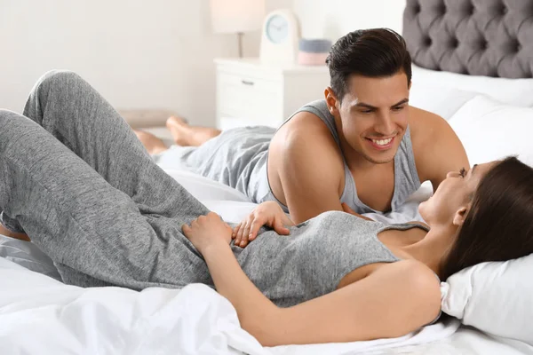 Портрет прекрасной молодой пары, отдыхающей на большой кровати — стоковое фото