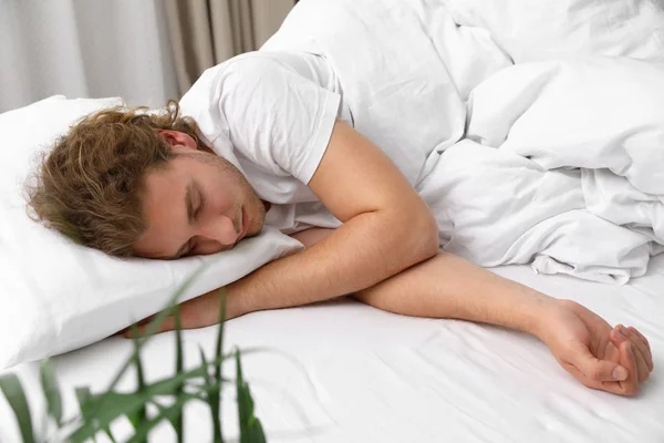 Snygg ung man sover på kudde hemma. Sänggåendet — Stockfoto