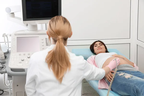 Mladá těhotná žena podrobena ultrazvukovém scanu v moderní klinice — Stock fotografie