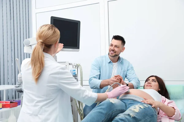 Man steunend zijn vrouw tijdens ultrasone klank scan in kliniek — Stockfoto