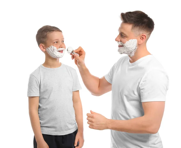Papa toepassen scheerschuim op zoon gezicht, witte achtergrond — Stockfoto