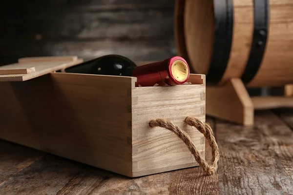 Jaula con botella de vino sobre mesa de madera —  Fotos de Stock