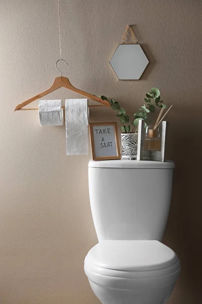 Elementos de decoração, necessidades e vaso sanitário perto da parede bege. Interior do banheiro — Fotografia de Stock
